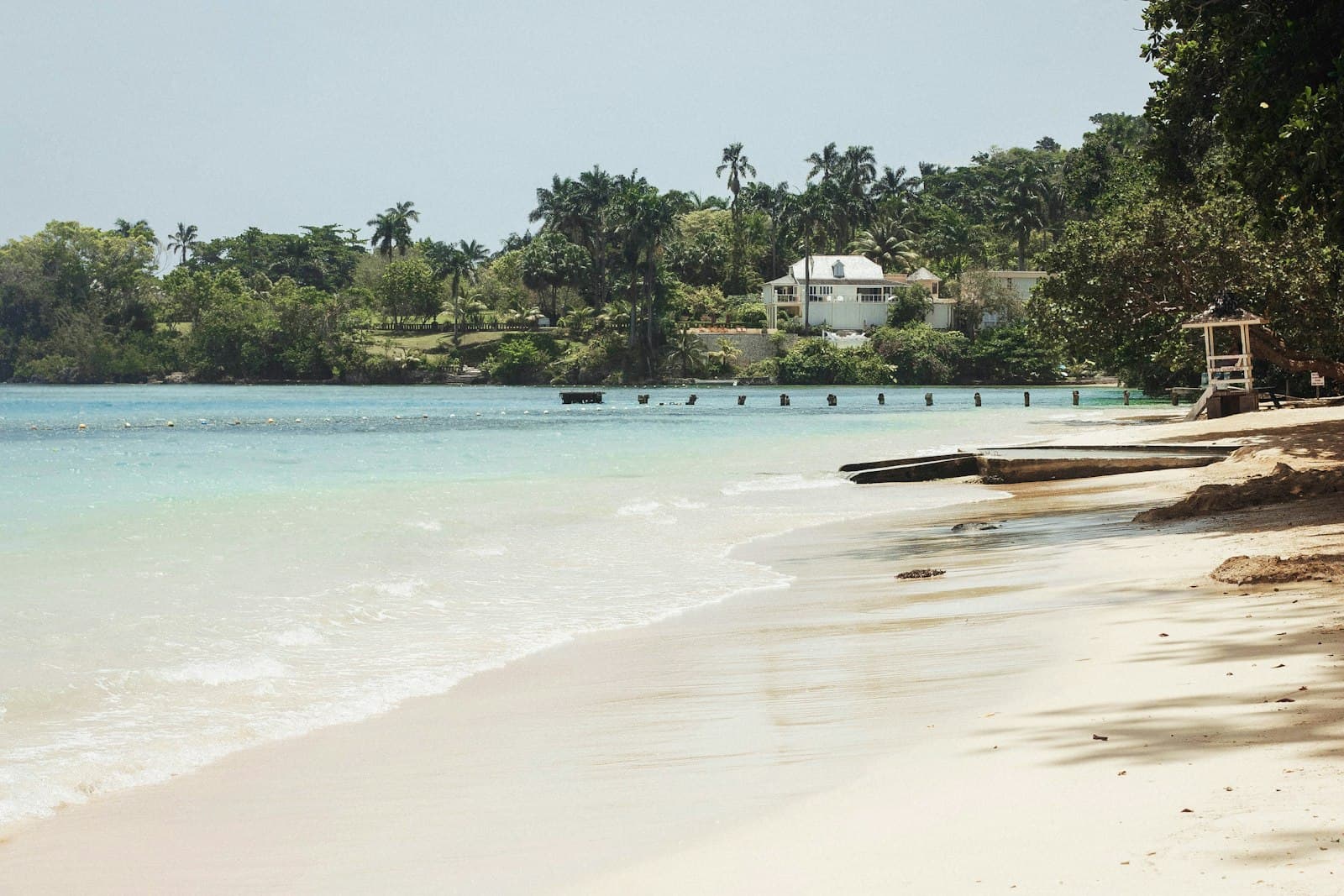 White-sand beach and turquoise water lined with palm trees near Ocho Rios, Jamaica