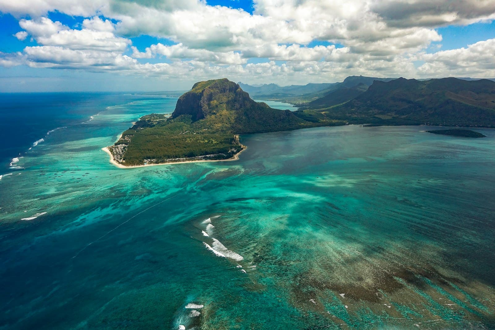 Aerial view of Le Morne Brabant rising above the turquoise lagoon and reef on Mauritius's southwest coast