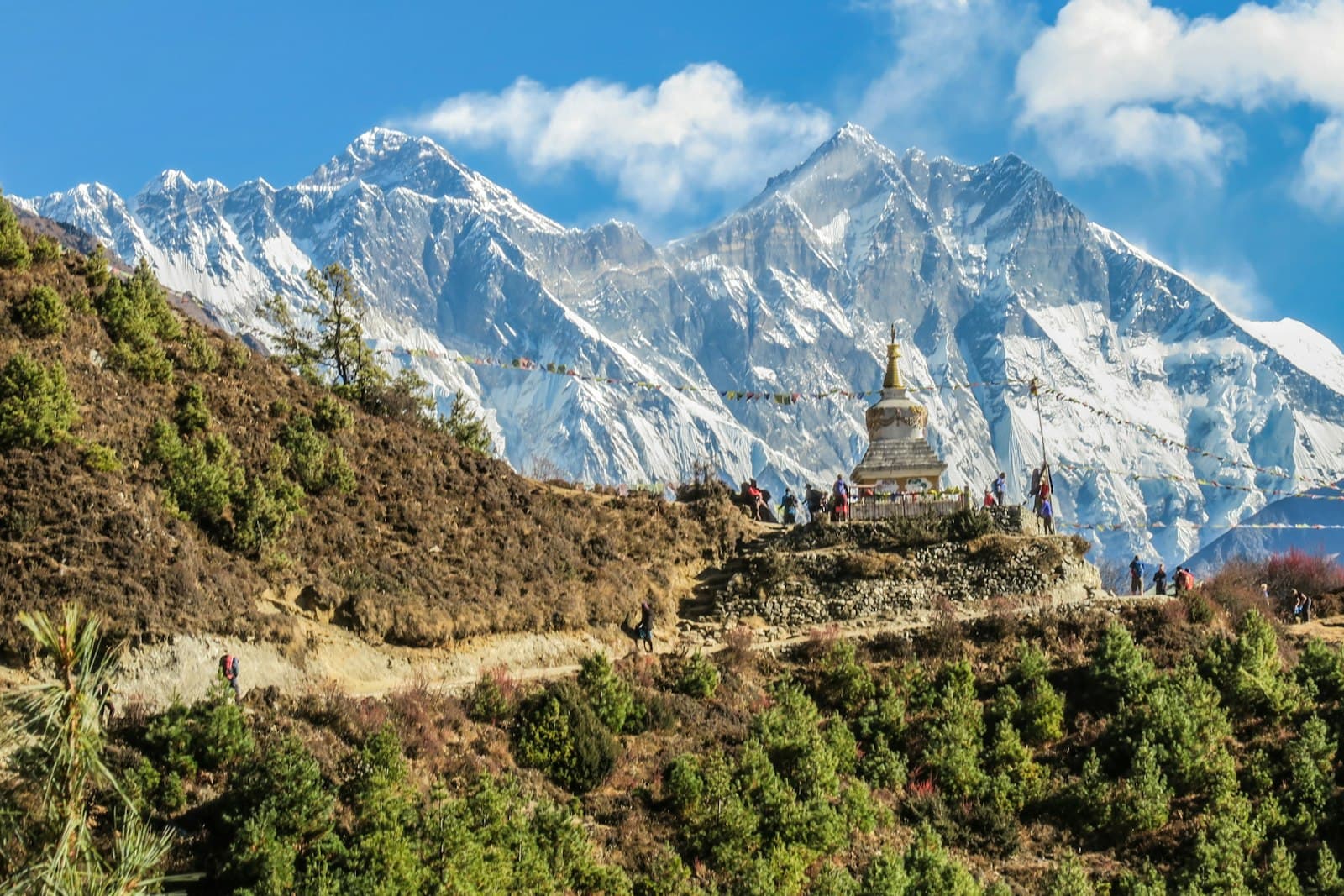 A Buddhist stupa and prayer flags above Namche Bazaar, with the snow-capped peaks of the Everest region behind