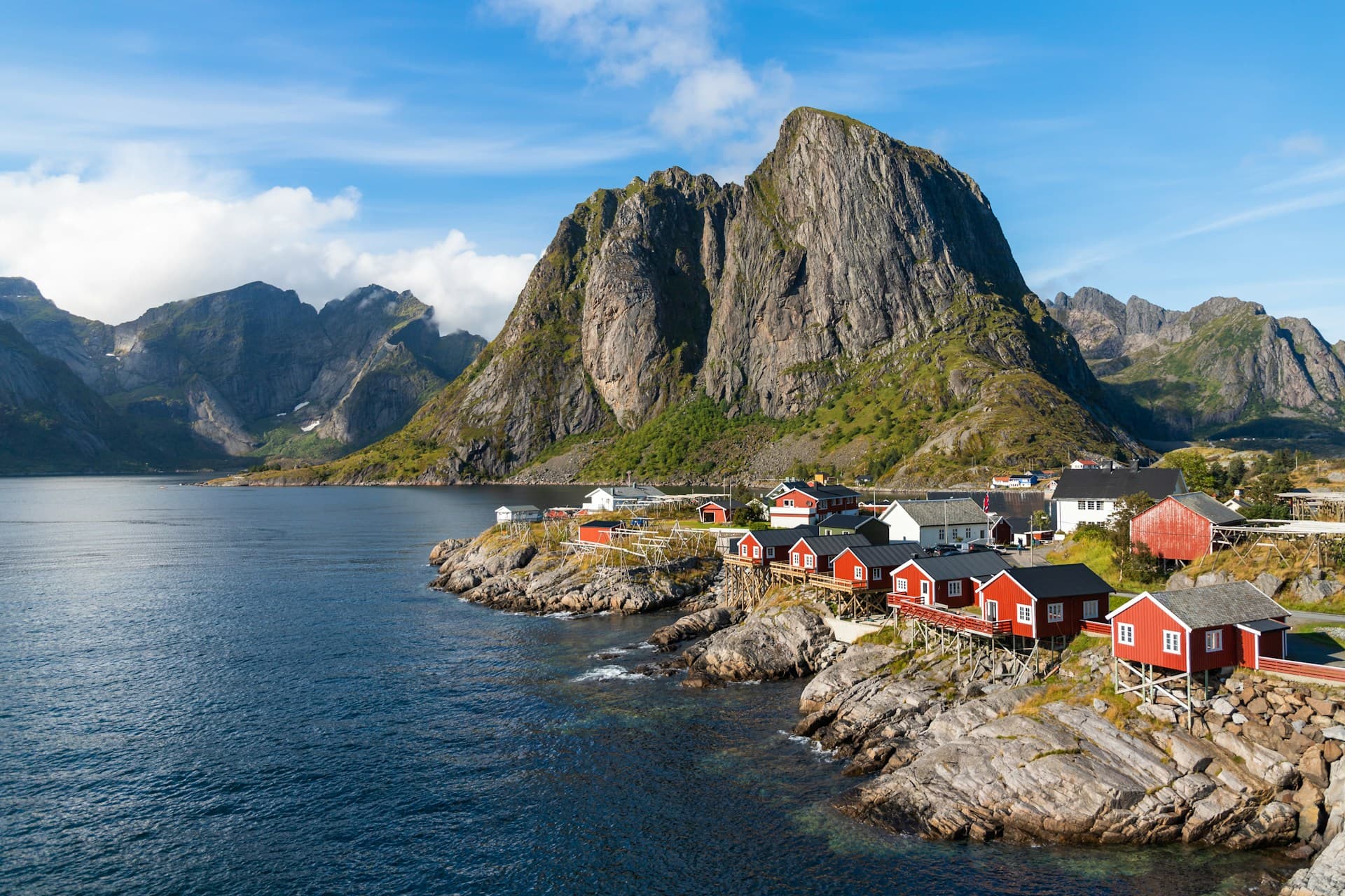 Reine fishing village in the Lofoten Islands with red rorbu cabins and dramatic mountain peaks