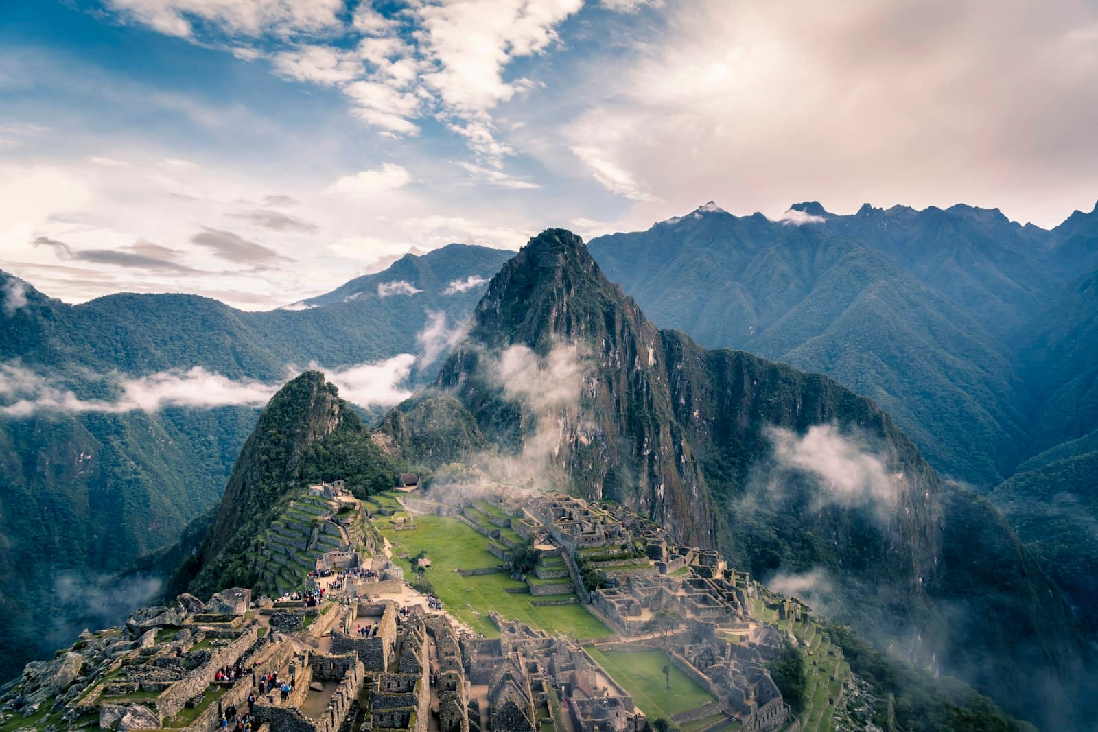 Machu Picchu citadel and Huayna Picchu peak with mist drifting over the Andes