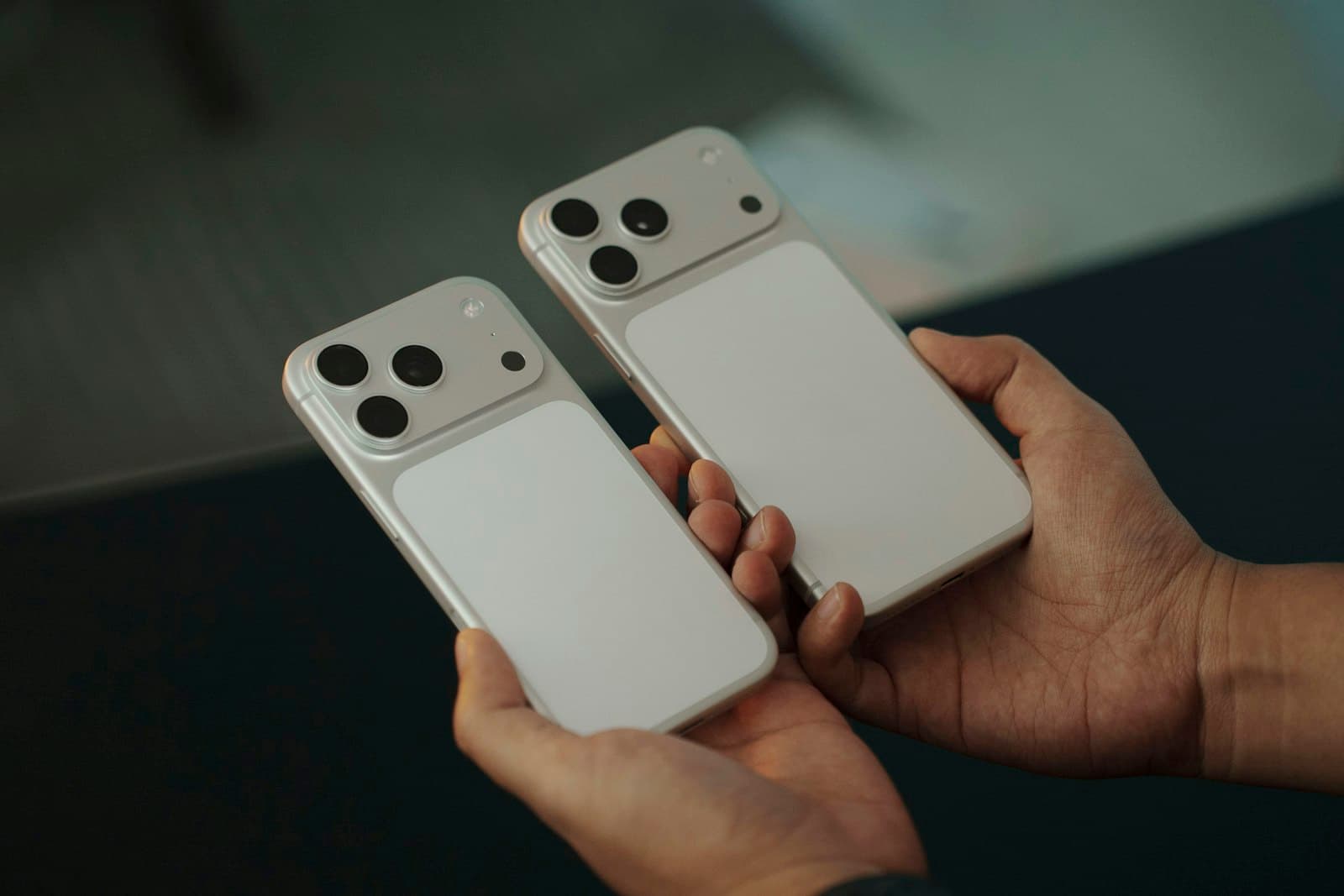 Hands holding two iPhones side by side while switching to a new phone