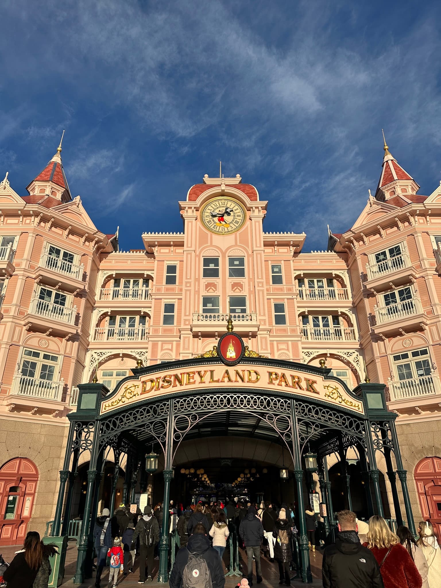 The Disneyland Park entrance building with its ornate clock tower and crowds entering
