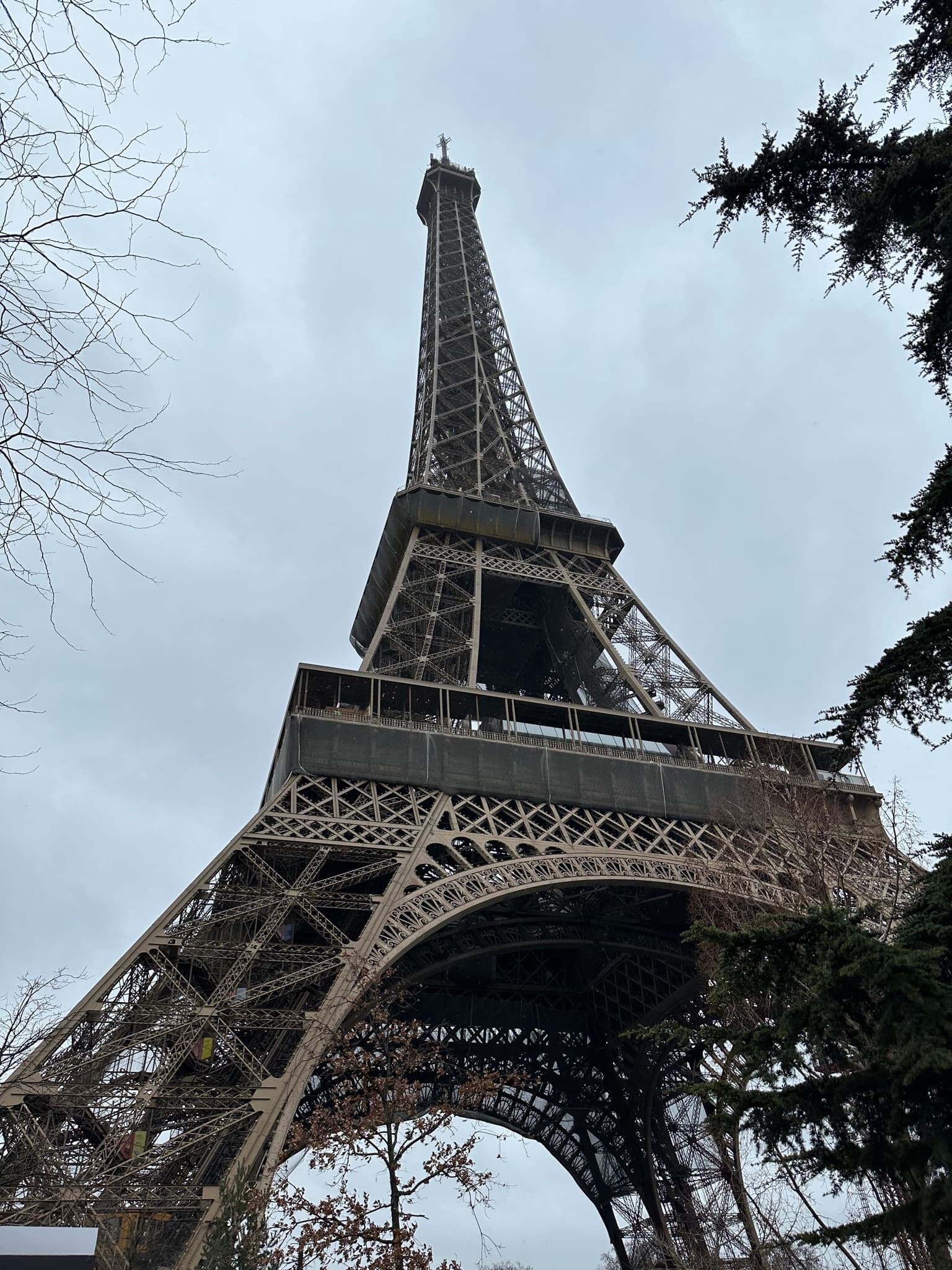 Looking up at the Eiffel Tower from the base on an overcast winter day in Paris
